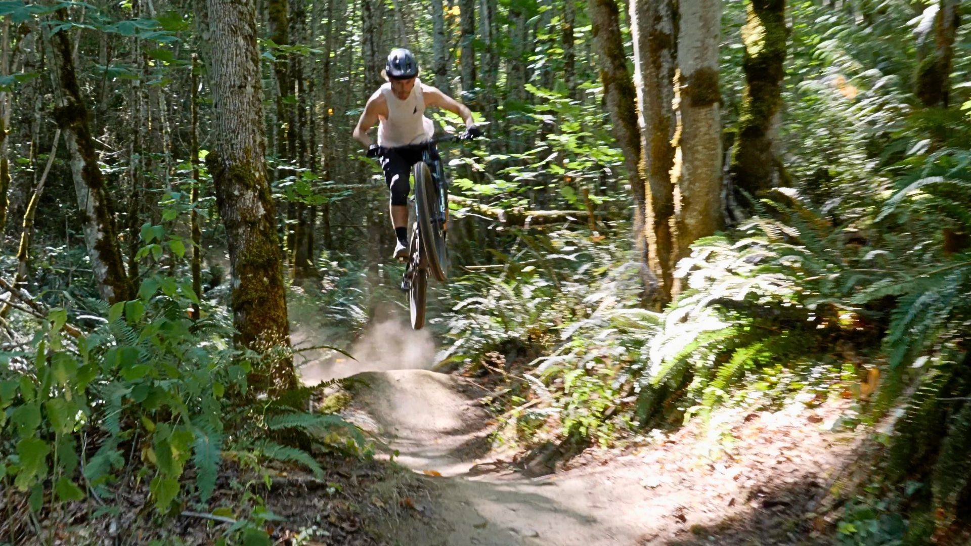 mountain bike rider jumping over trail