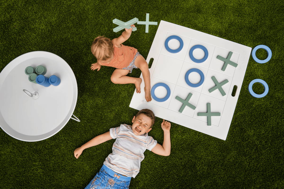 Two kids play giant outdoor games like tick-tac-toe, and one cries because he lost.