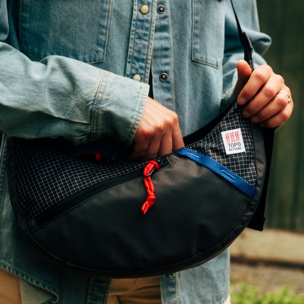 Person holding a black and blue bag with a mesh design.