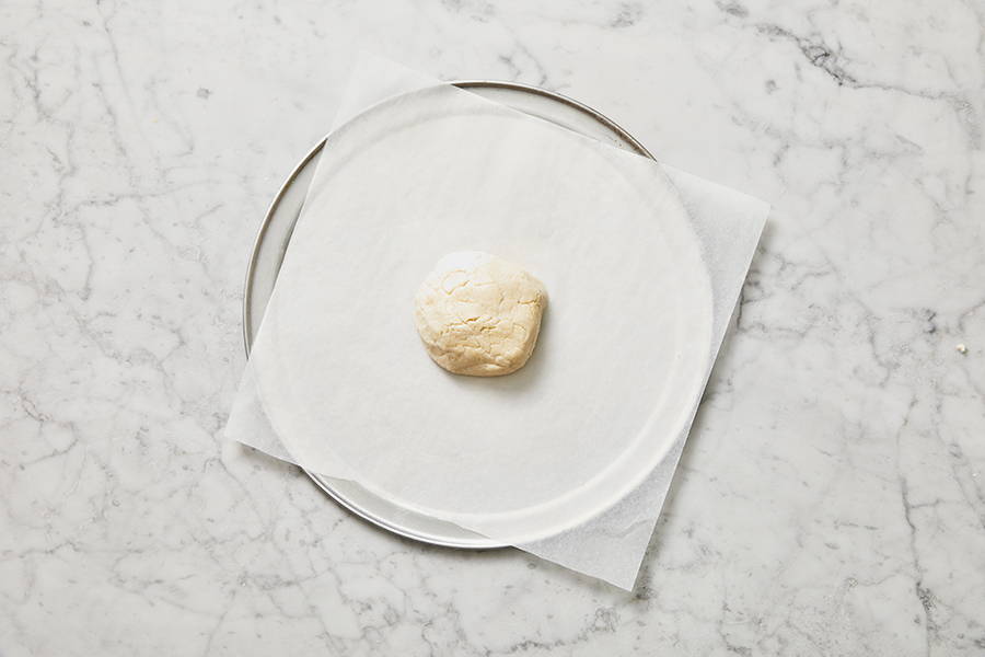 Dough placed on a baking sheet covered in parchment paper