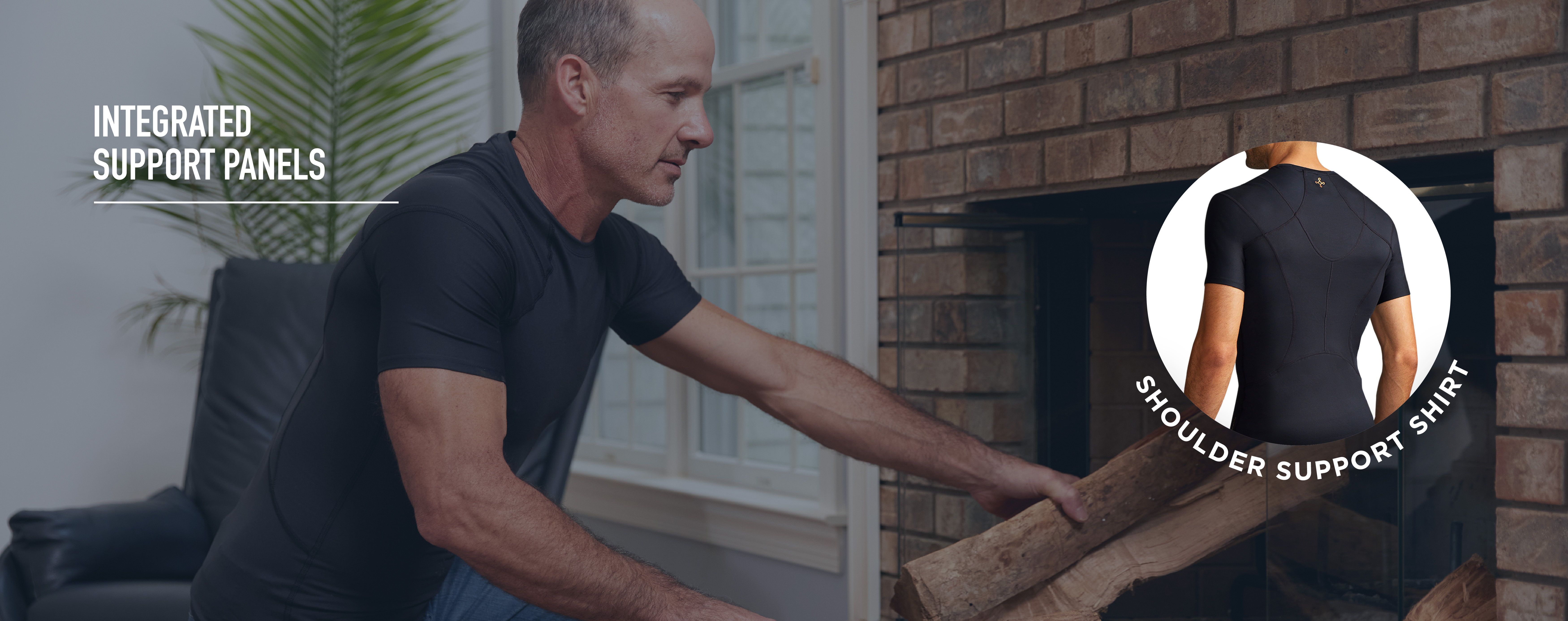 Man placing logs in a fireplace wearing the Shoulder Support Shirt