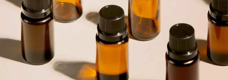 Brown glass bottles with black lids on a light surface.