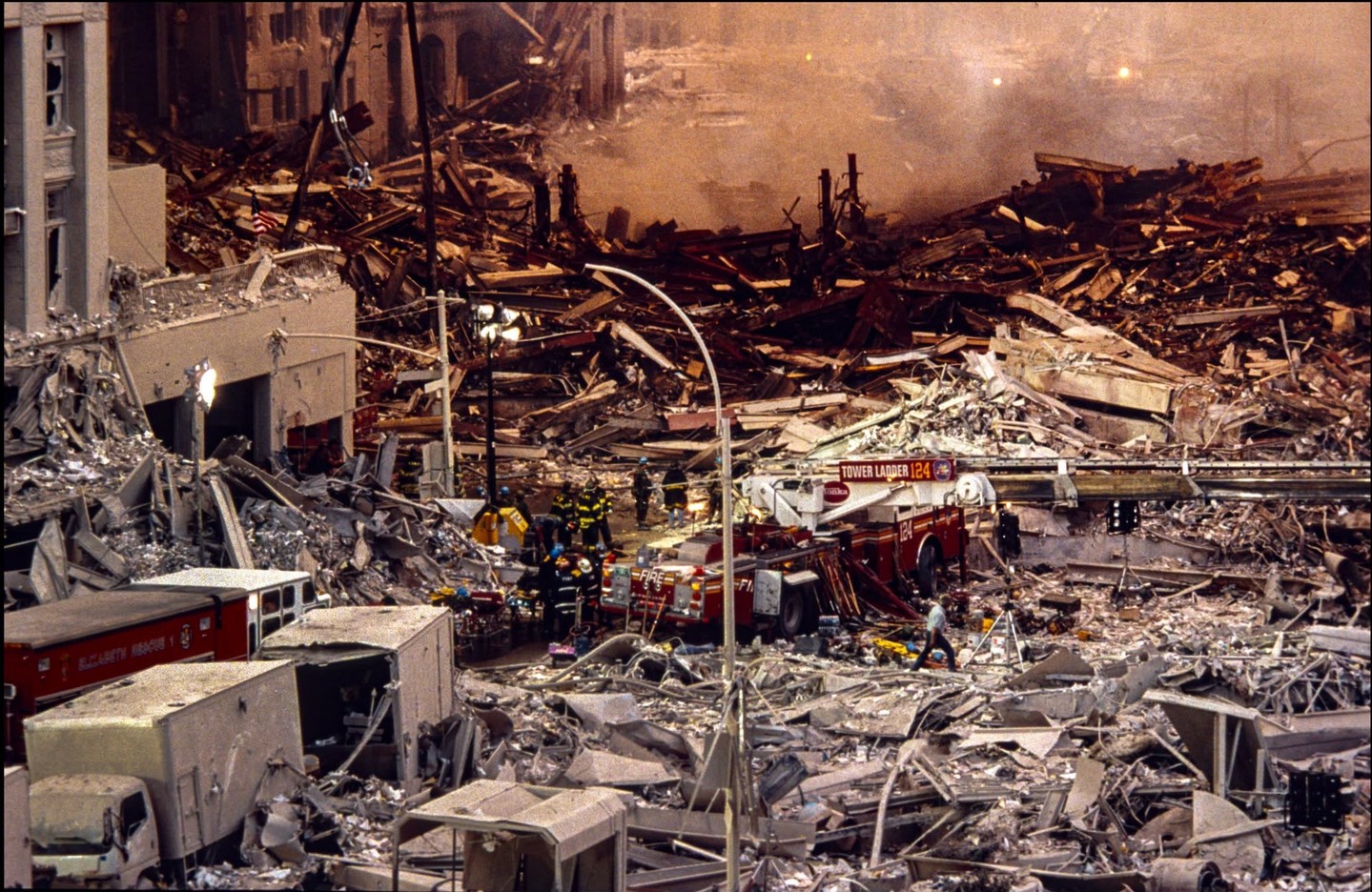 Debris and emergency services at a disaster site in an urban area.