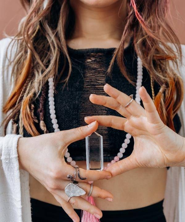 woman holding clear quartz crystal point