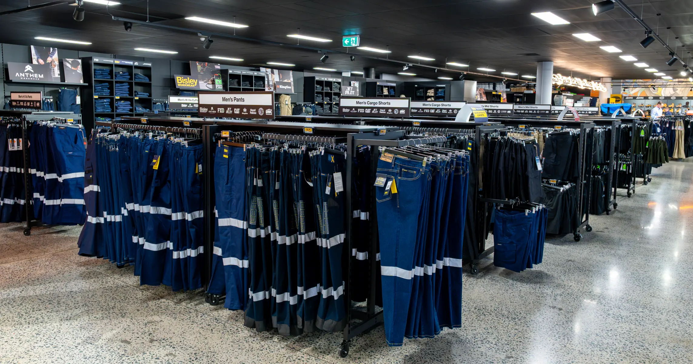 Clothing racks displaying various styles of pants in a retail store.