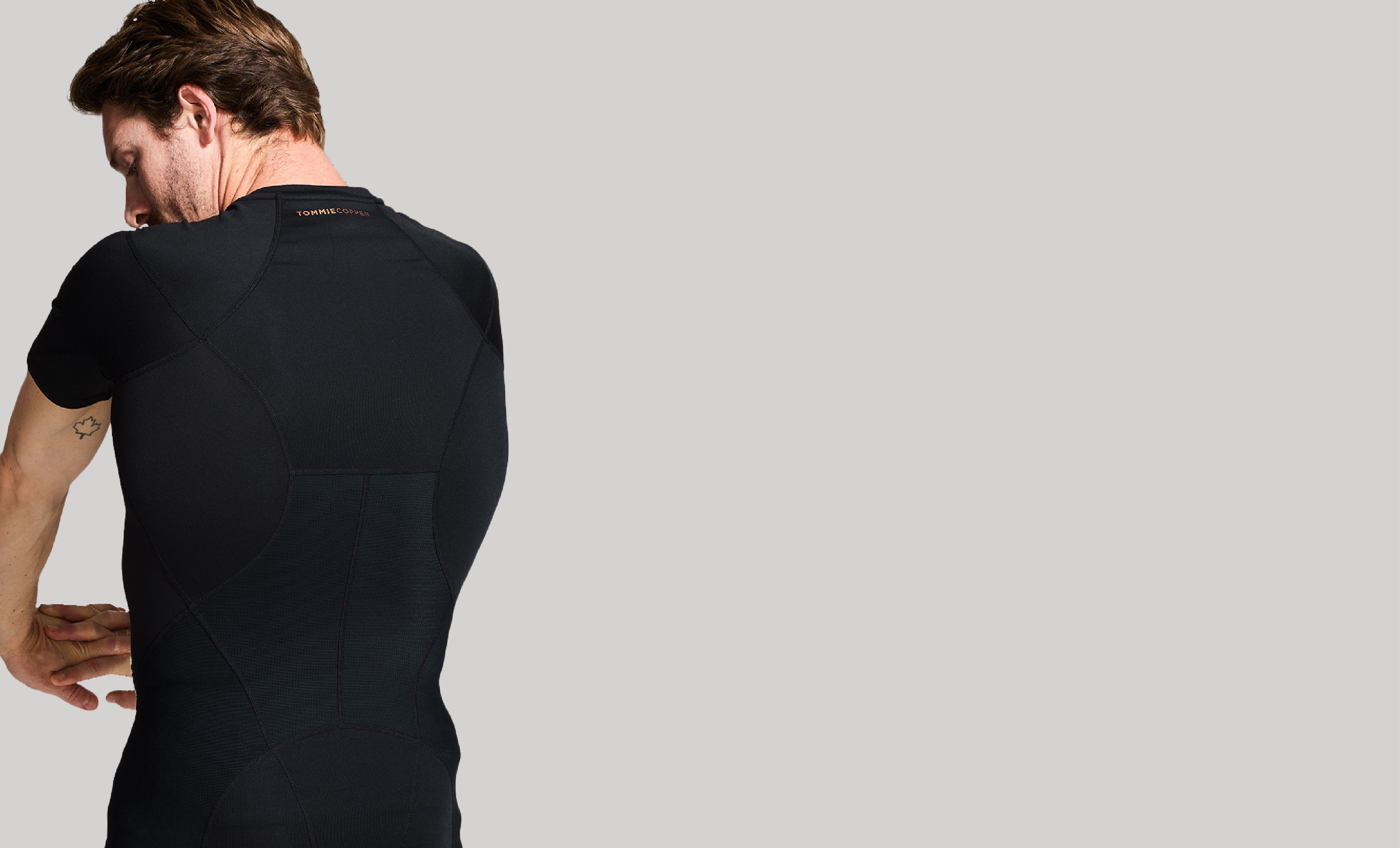 A man wearing a black Full Back Support compression shirt.
