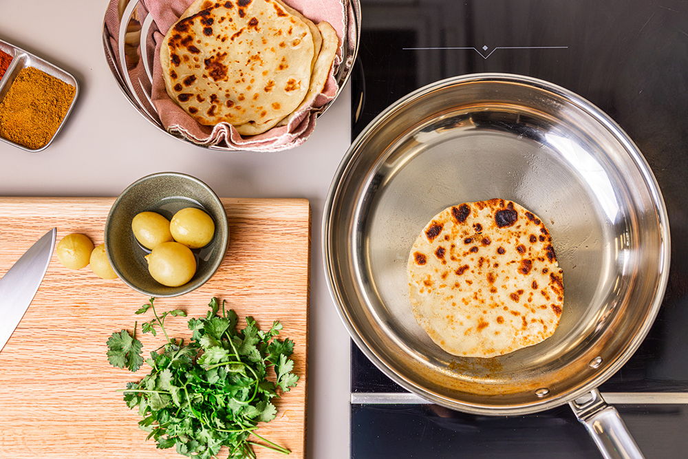 Flatbread cooking in a 316 Series Frying Pan with ingredients on the side.