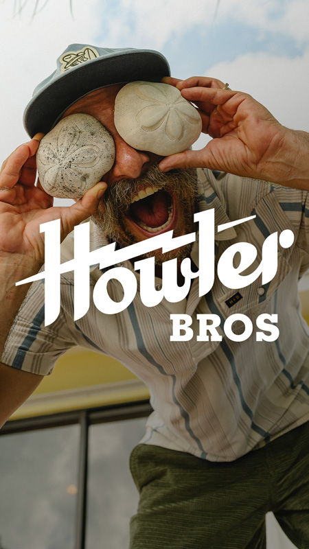 Man holding stones over his eyes, smiling, with 
