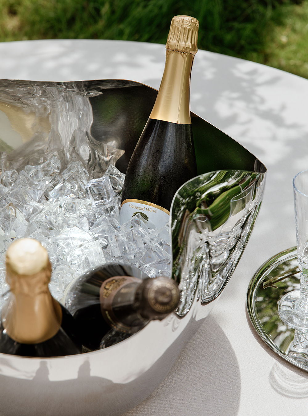 Chilled champagne bottles in a Drift Champagne Bucket with glasses nearby.