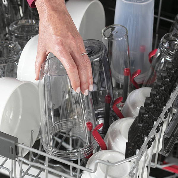 Woman loading top rack of GE Appliances dishwasher