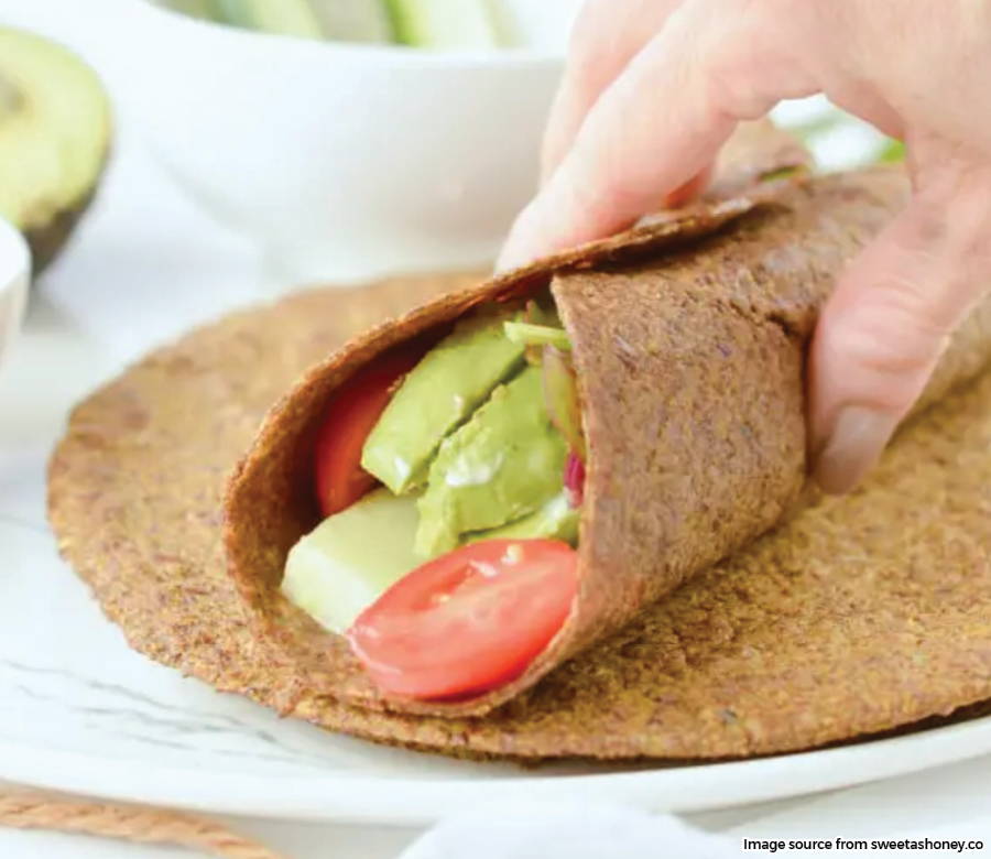 hand holding wrap with fresh veggies