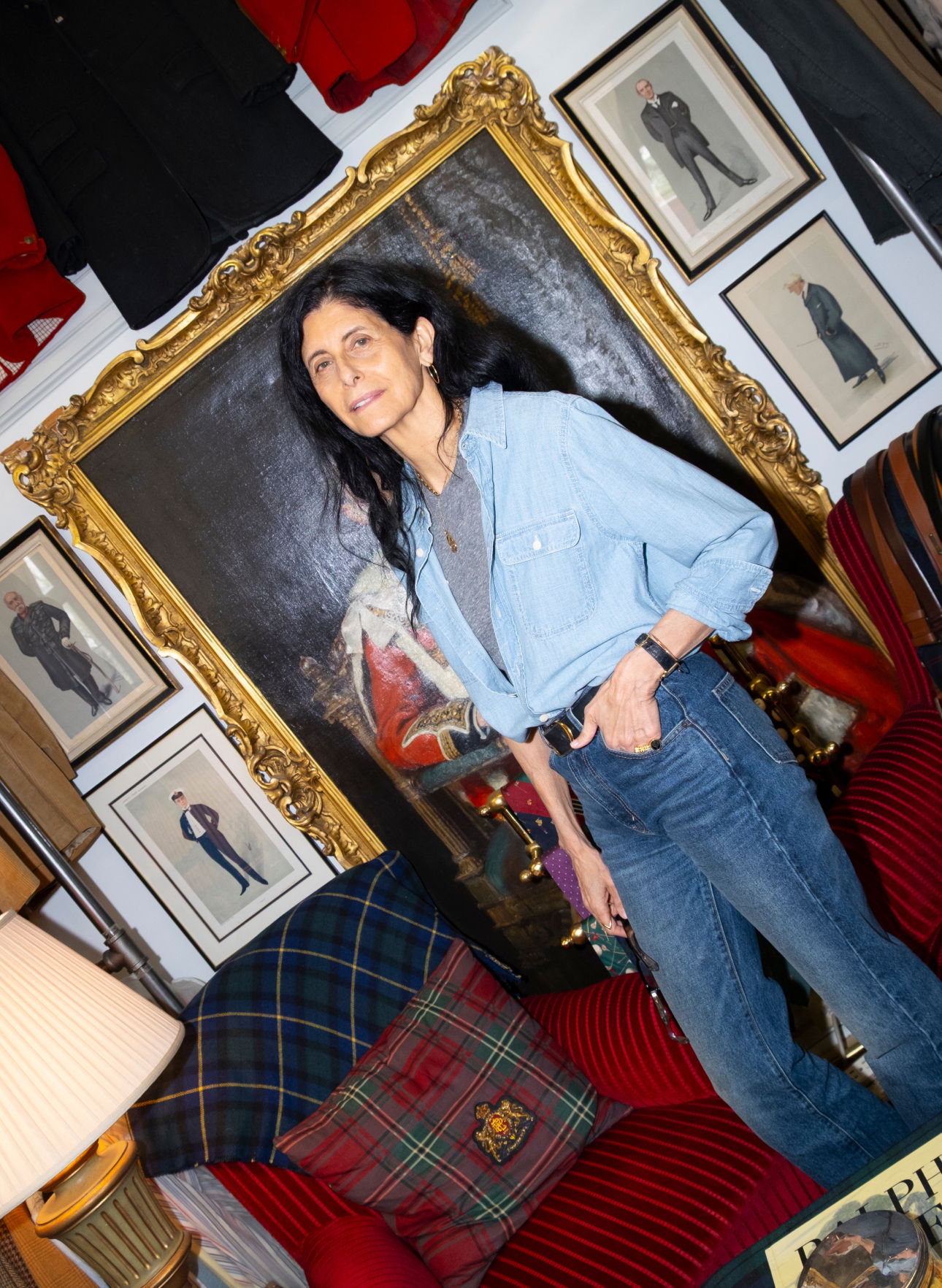 Woman in a blue shirt stands in a room with vintage decor.