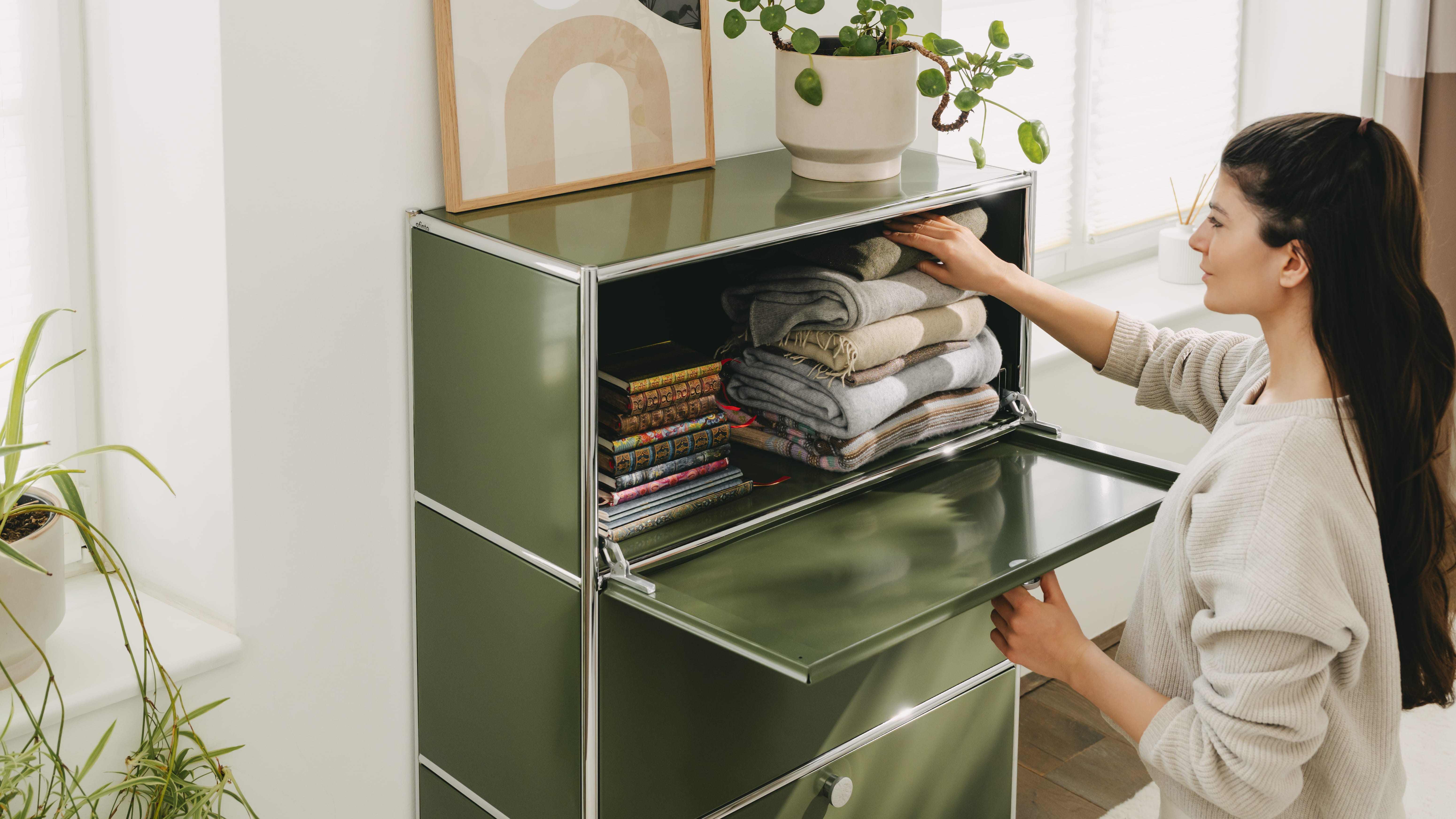 Frau organisiert ihr Cubox Büroregal in ihrem Wohnzimmer