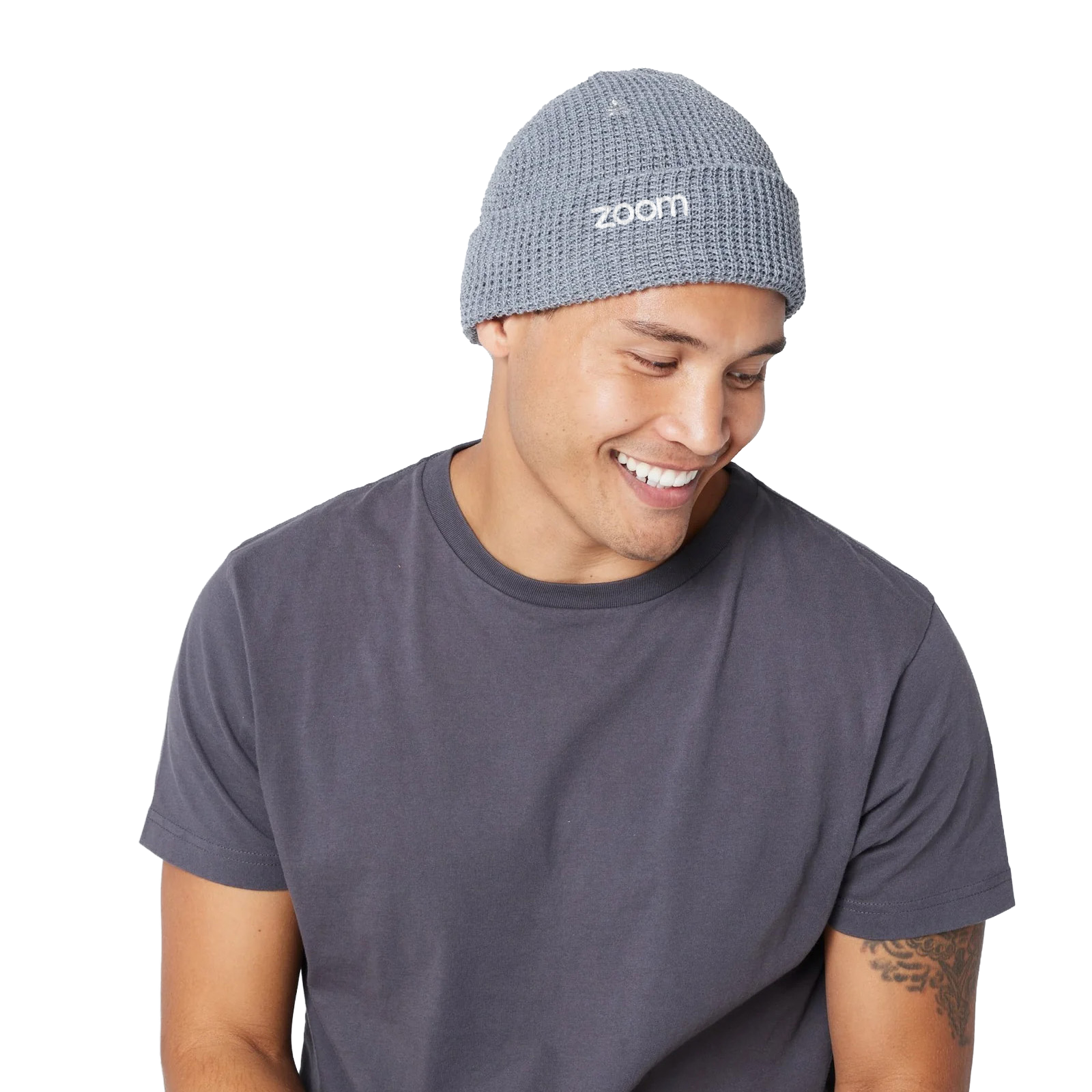 Smiling person wearing a gray Zoom beanie and a dark shirt.