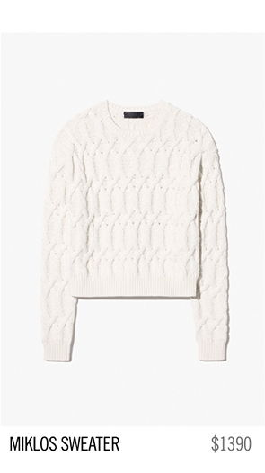 White cable-knit sweater labeled 