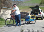 Man rock on gesture red mountain bike blue yellow child trailer white pickup camper shell green hillside Will's Shocker XL train horn featured customer install gallery photo 1