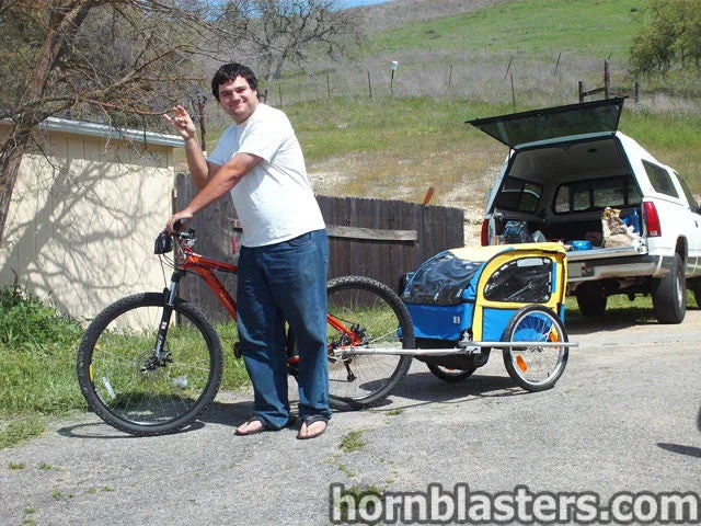 Man rock on gesture red mountain bike blue yellow child trailer white pickup camper shell green hillside Will's Shocker XL train horn featured customer install gallery photo 1
