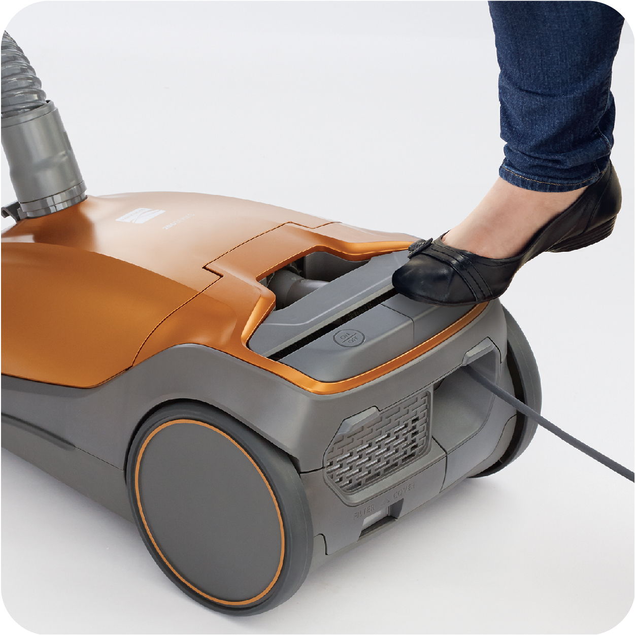 Person's foot on a vacuum cleaner's pedal with a power cord.