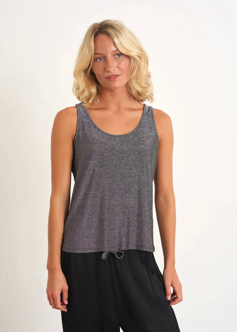 A model wearing a dark grey sparkly vest with black trousers