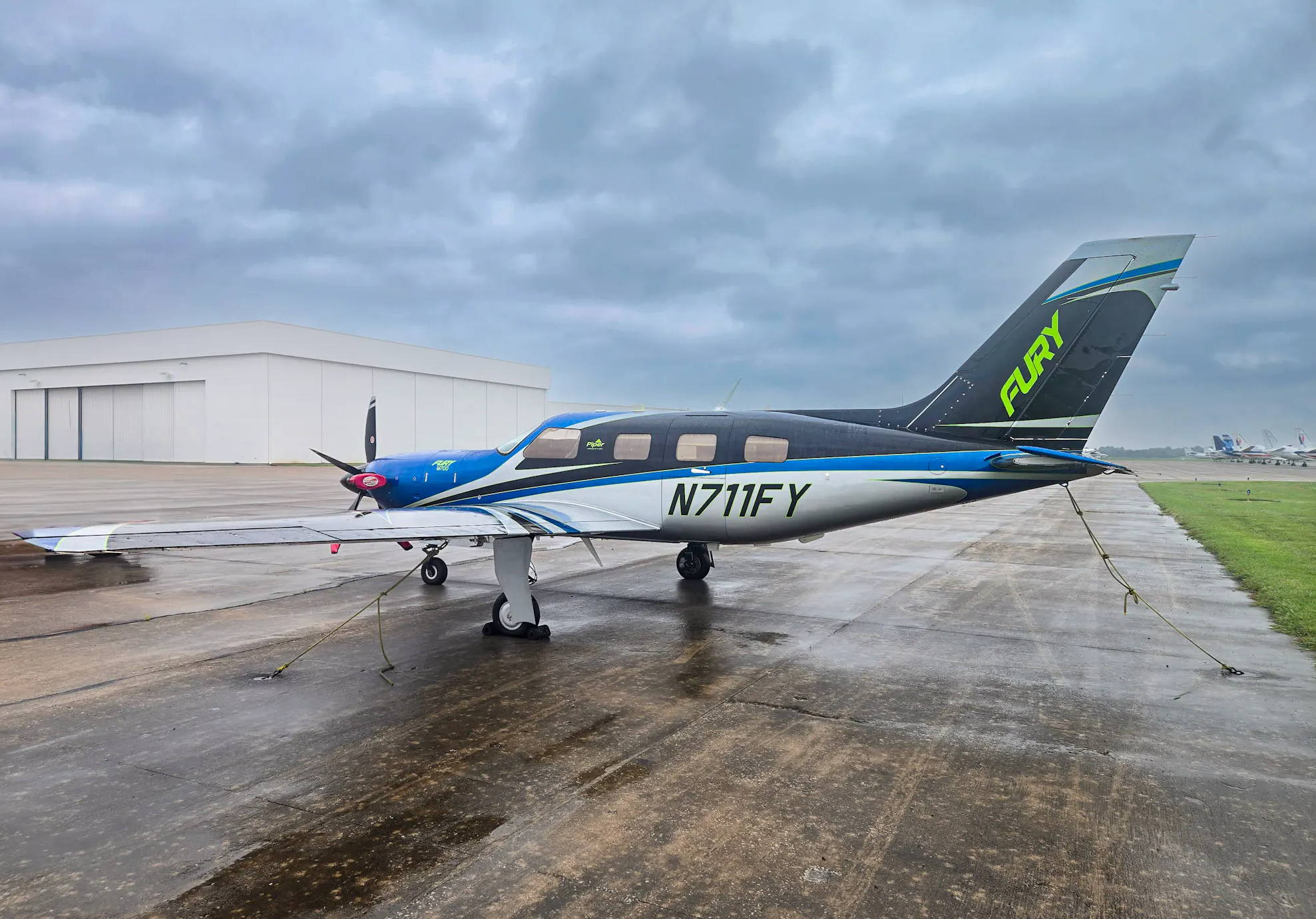 Small aircraft on a runway with overcast sky in the background.