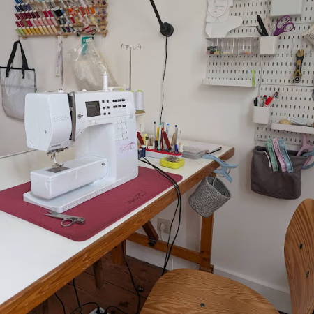 sewing machine table with a peg board on the wall