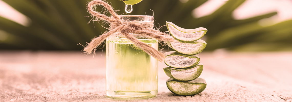 A jar of aloe vera with lime slices in soft lighting.