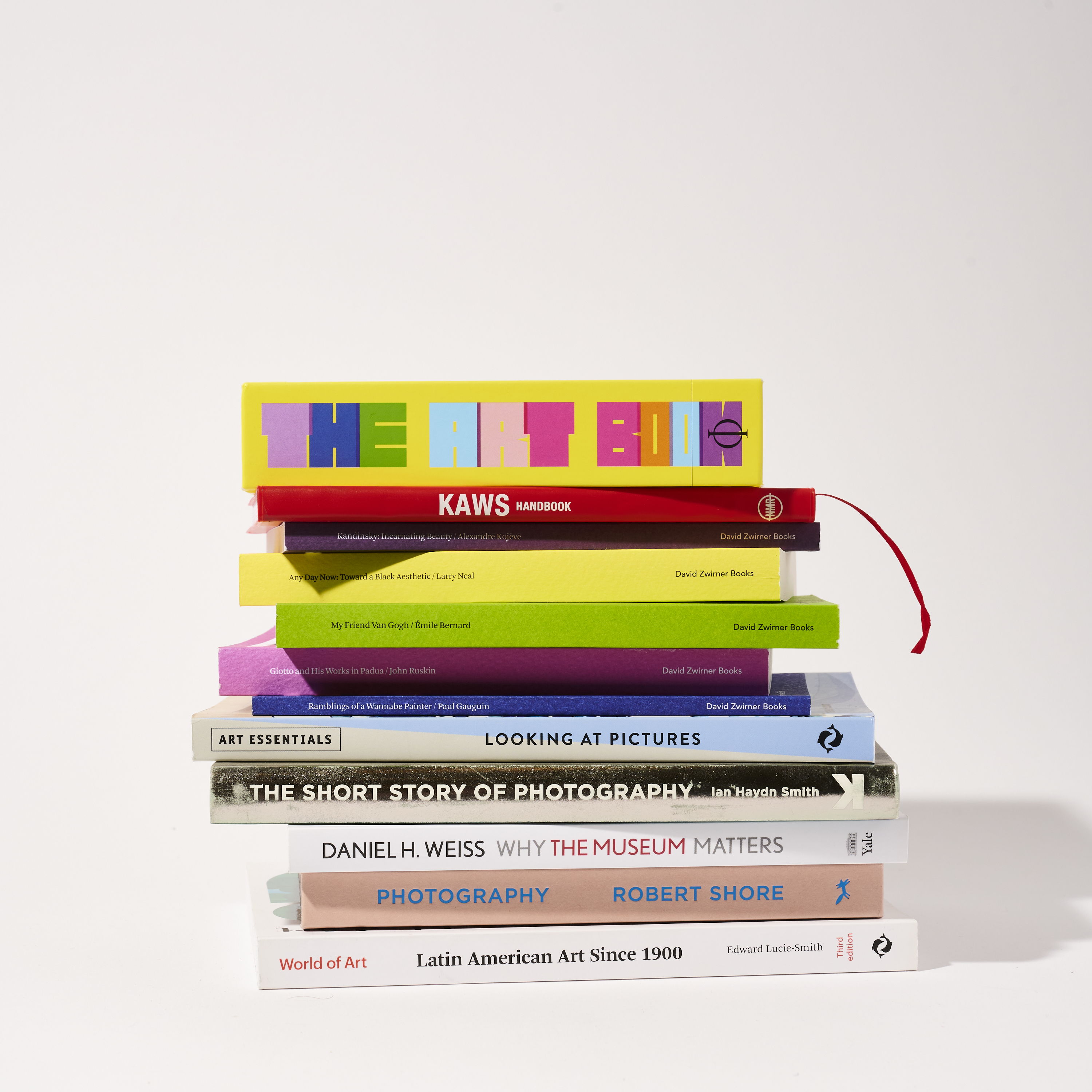 A stack of colorful books on a plain background.
