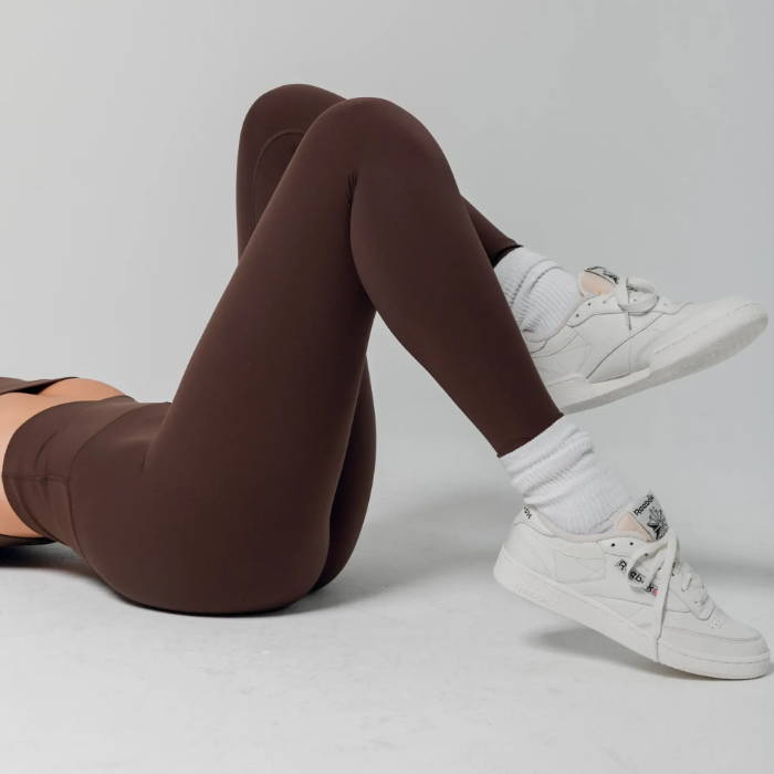female model wearing brown sacre leggings
