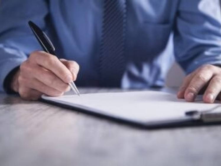 Hands signing paperwork