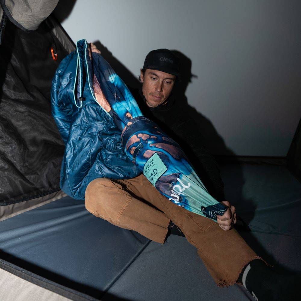 Chris Burkard sitting in a tent with the Rumpl Original Puffy Blanket - Thjorsa