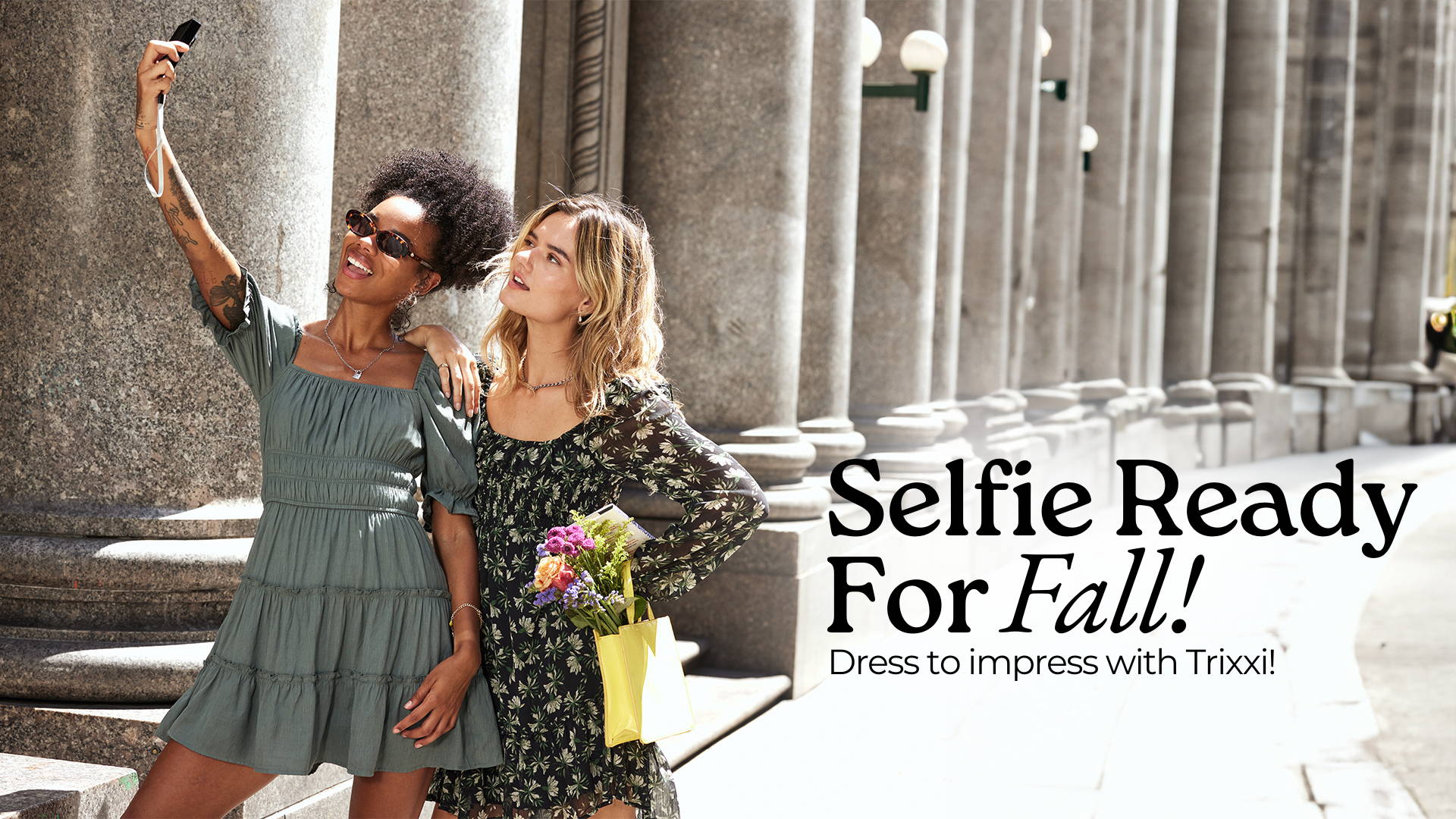 Selfie ready for fall, dress to impress in Trixxi, two girls in the city taking selfie images in a long sleeve black floral dress and sage green tier short sleeve mini dress.