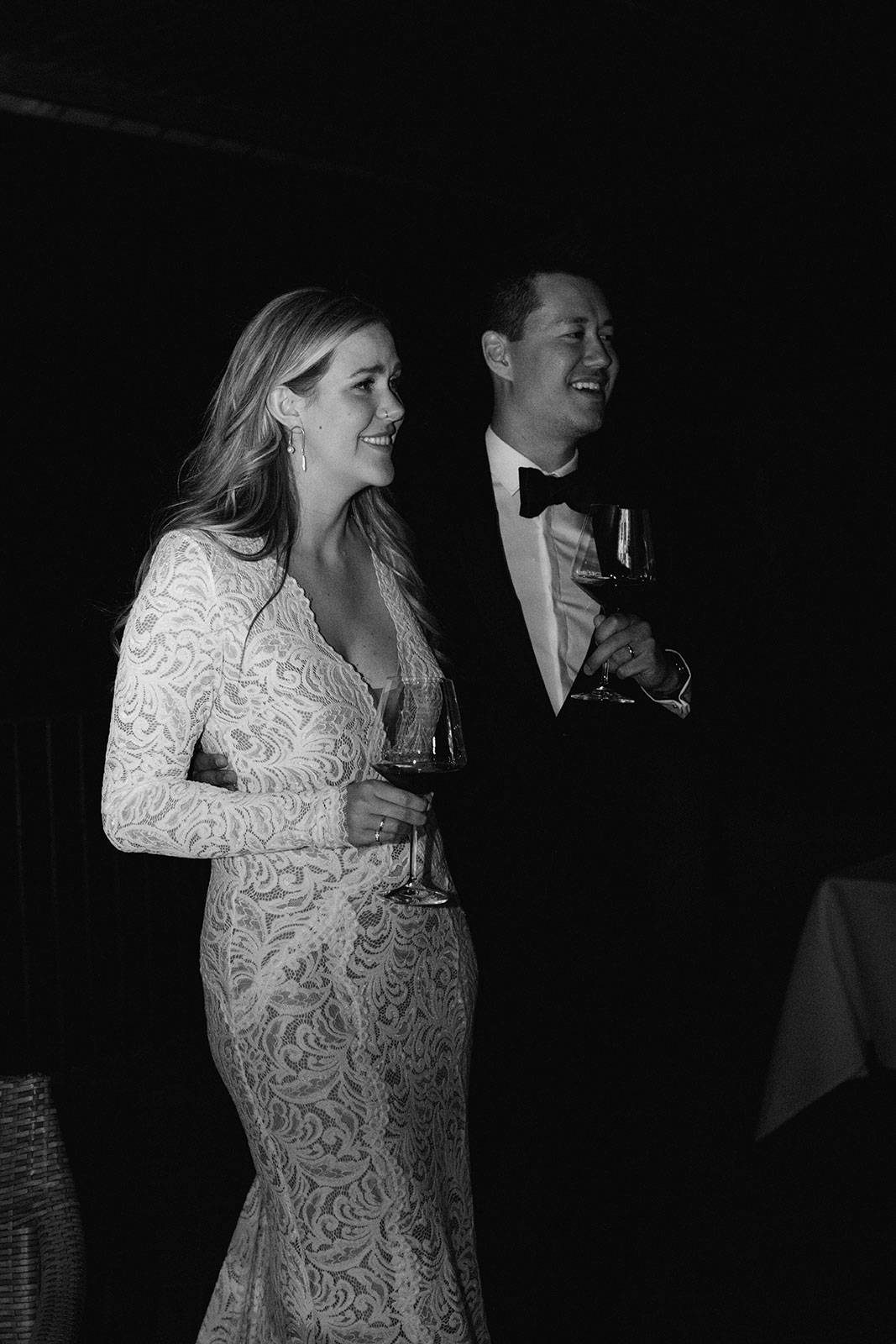 Black and white image of Bride and Groom holding a glass of wine
