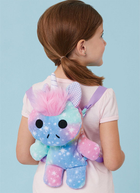 Child wearing a colorful unicorn backpack, facing away against a blue background.