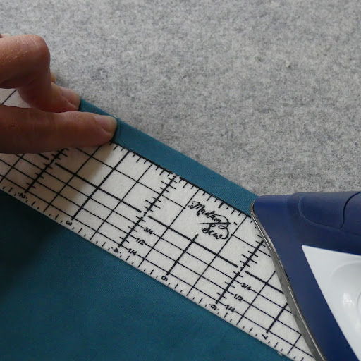 Using a hot hem ruler to iron a hem