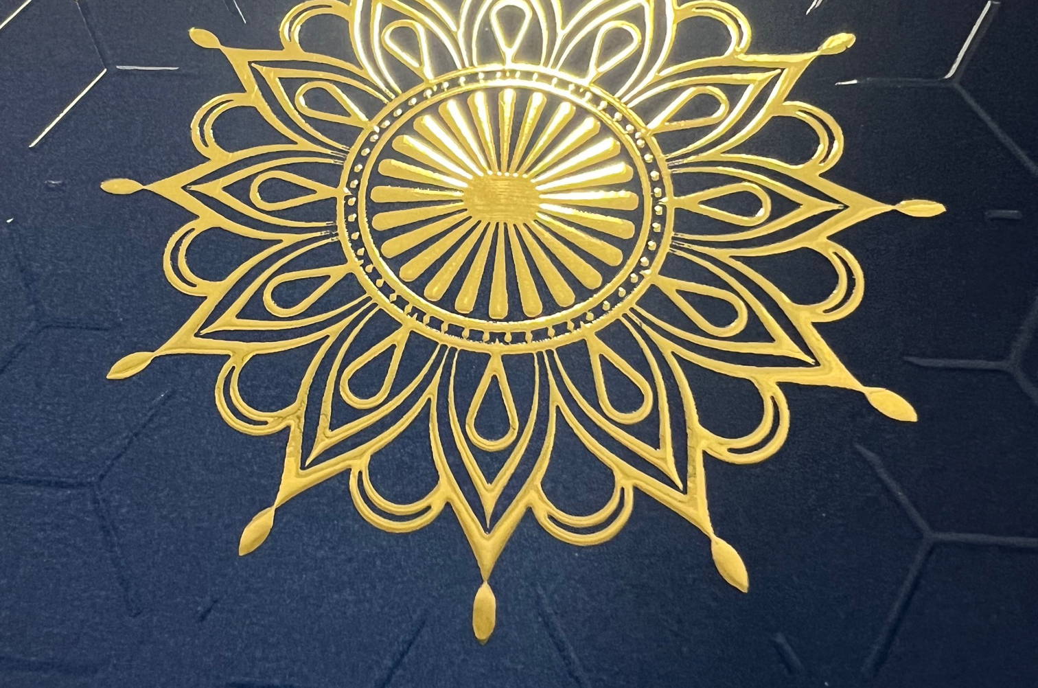 Raised gold and clear printing on a navy blue paper.