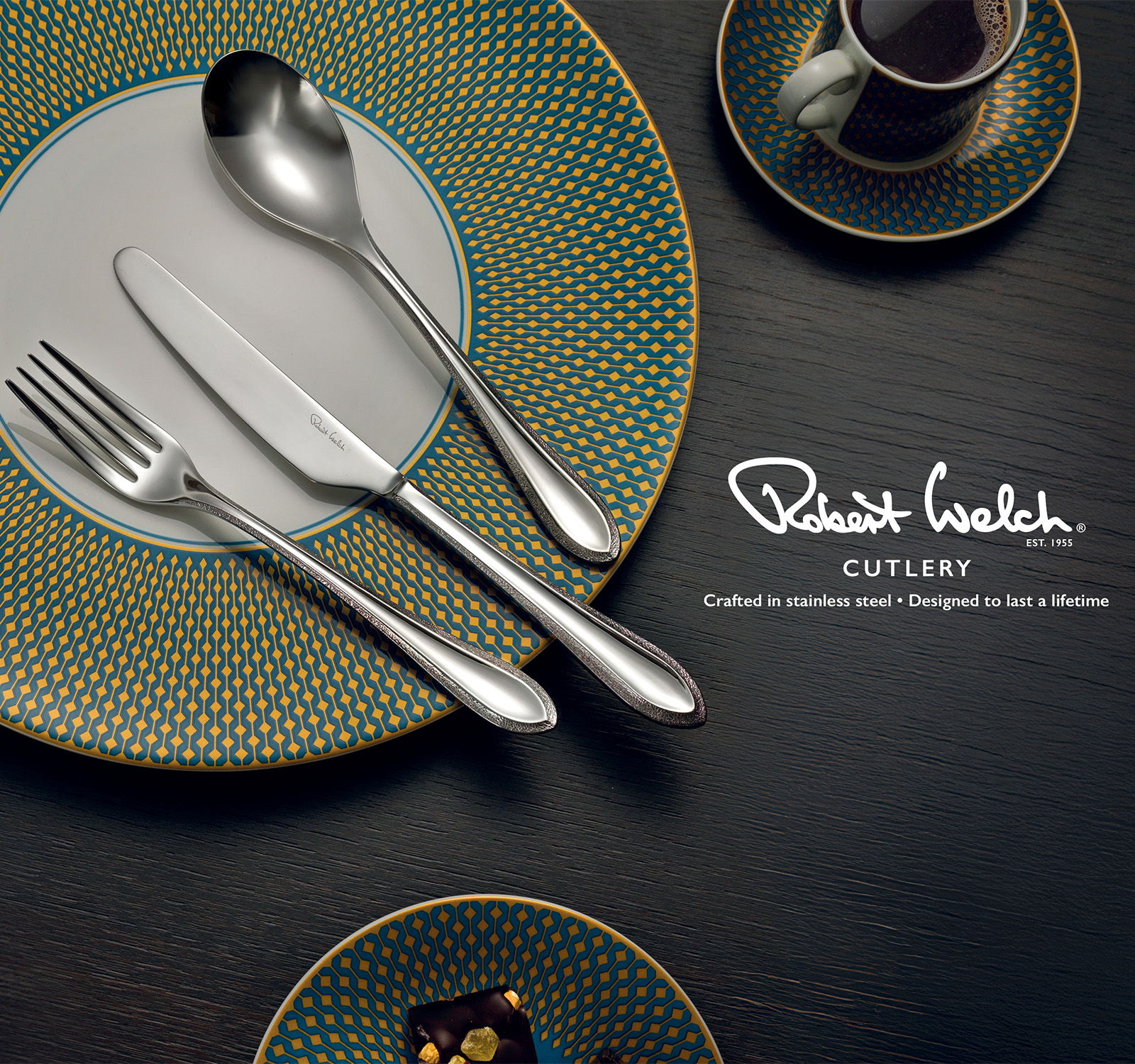 Cutlery displayed on a decorative plate with coffee cup and dessert.