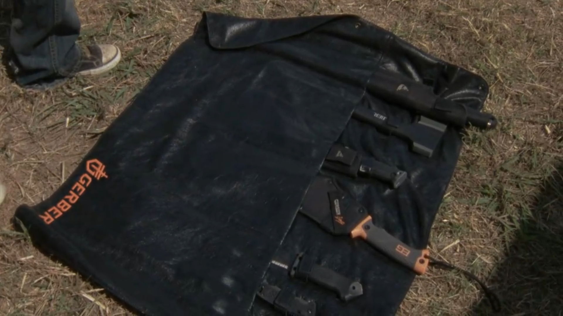 Black mat with pockets for tools, laid on grass.