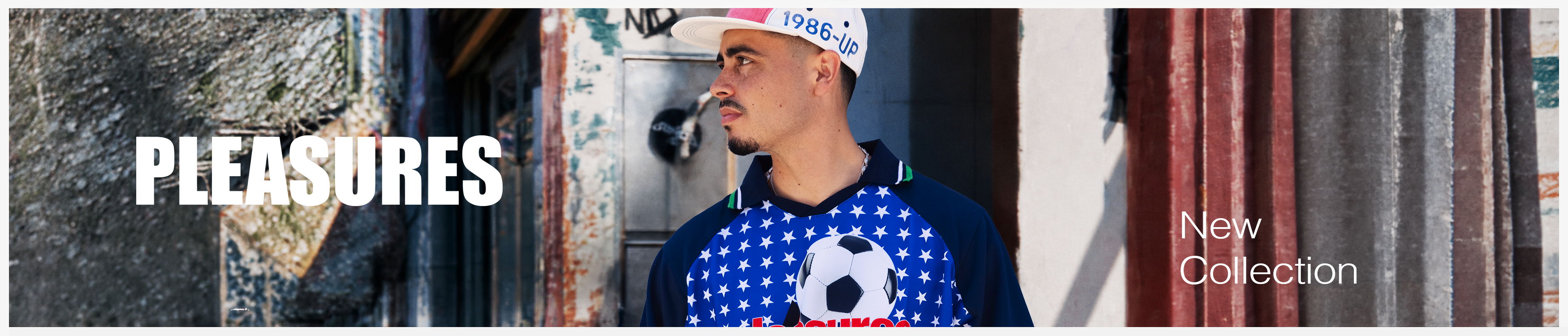 A person wearing a blue shirt next to a wall with text 
