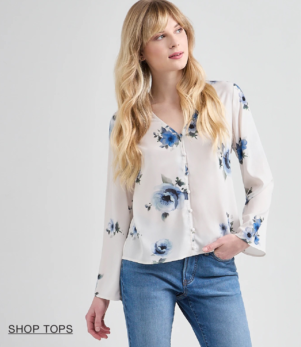 Woman wearing a floral blouse and jeans, looking away from the camera.