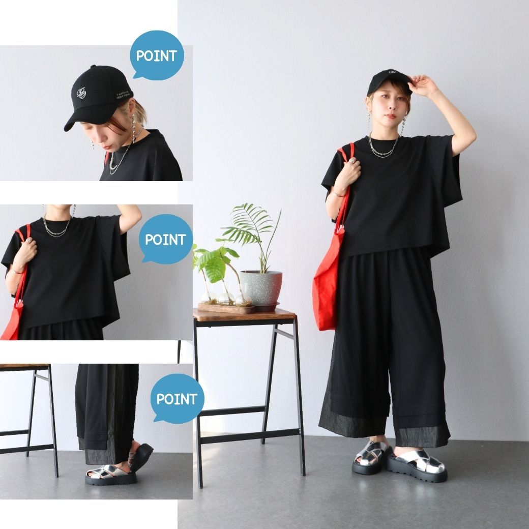 Person wearing black outfit with a cap and red bag, posing indoors.