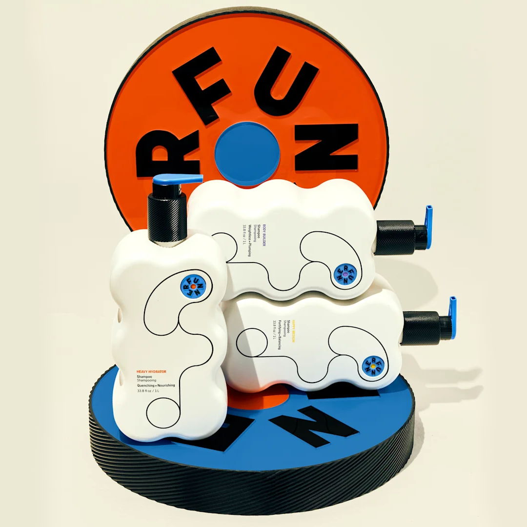 Three bottles of lotion on a colorful circular base with 