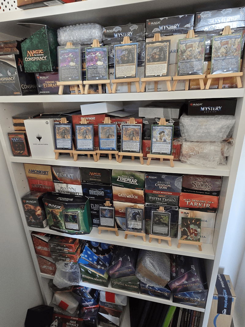 A shelf filled with various card game boxes and accessories.