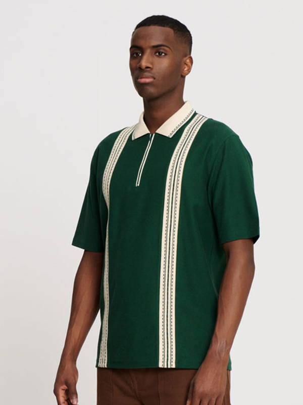 A model wearing the Palmes Luca Zip Polo in green with beige stripes.