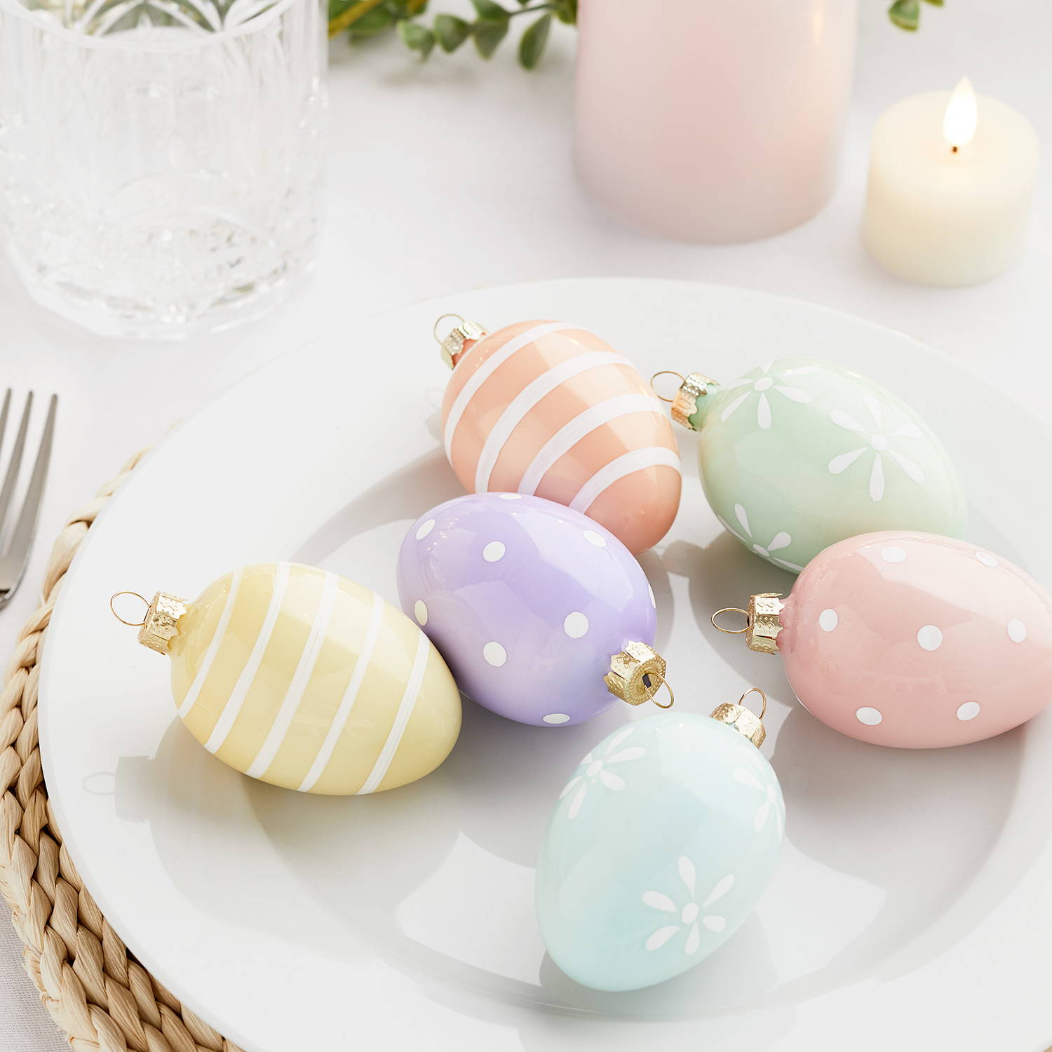 6 pastel coloured galss egg decorations on a plate as part of an Easter dining experience.