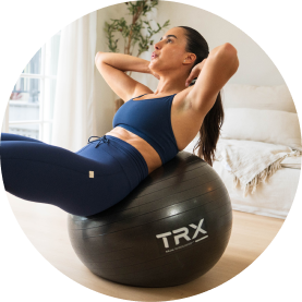Woman exercising on a stability ball in a bright, indoor setting.