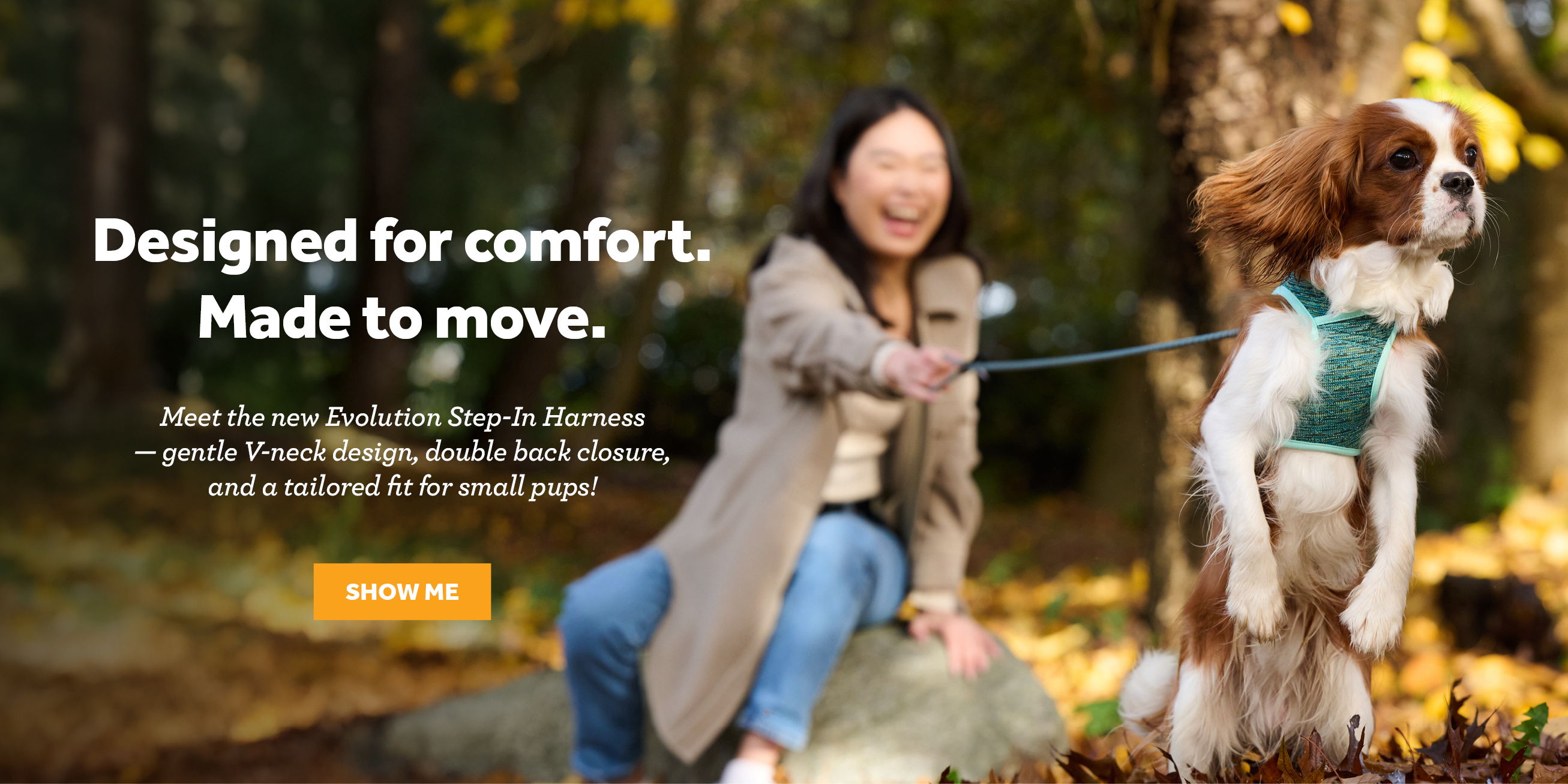 Person smiling with a dog in a forest setting.