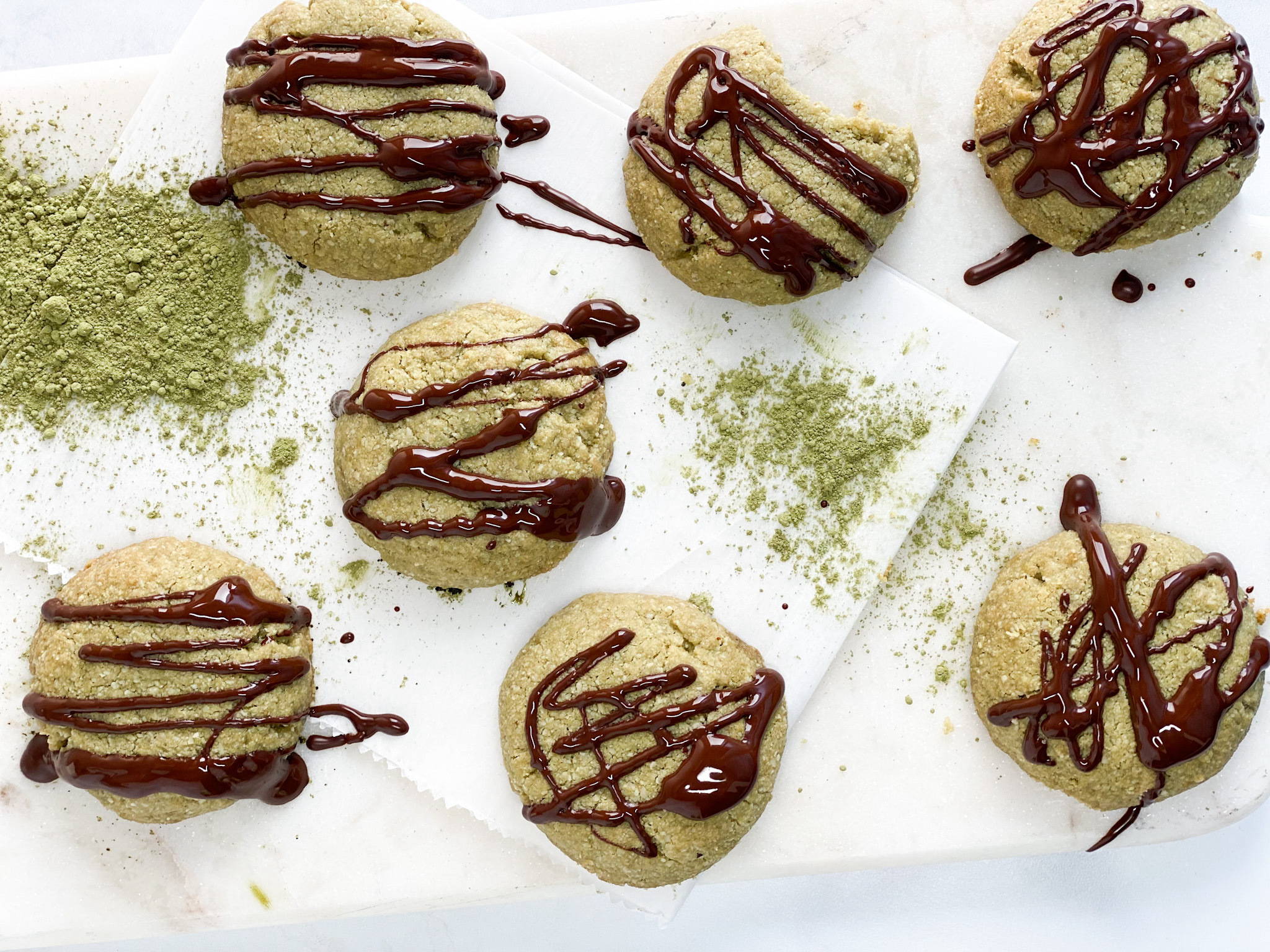Paleo Matcha Collagen Cookies with a dark chocolate drizzle on top.