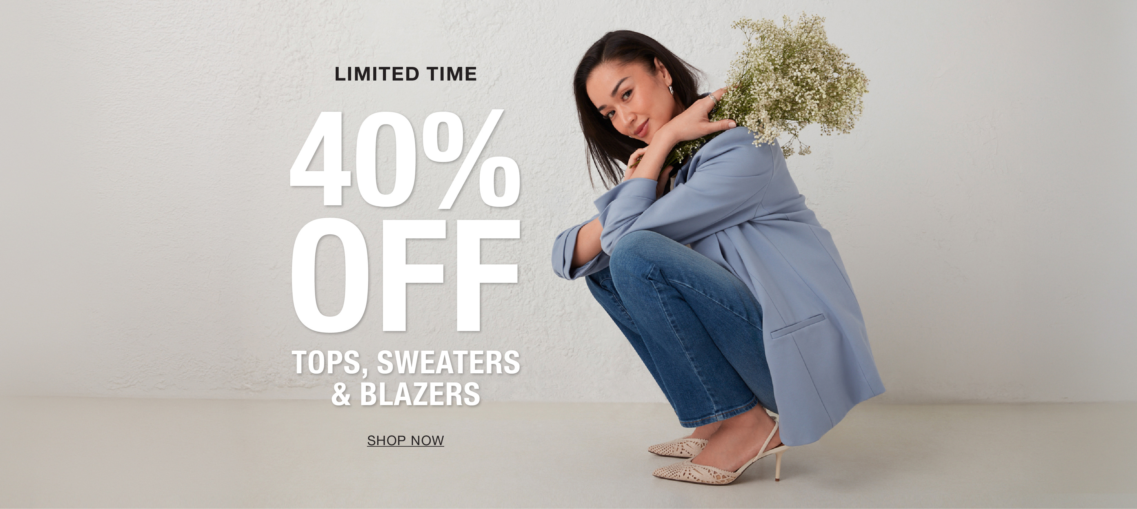 Woman holding flowers, promoting 40% off tops, sweaters, and blazers. Limited time.