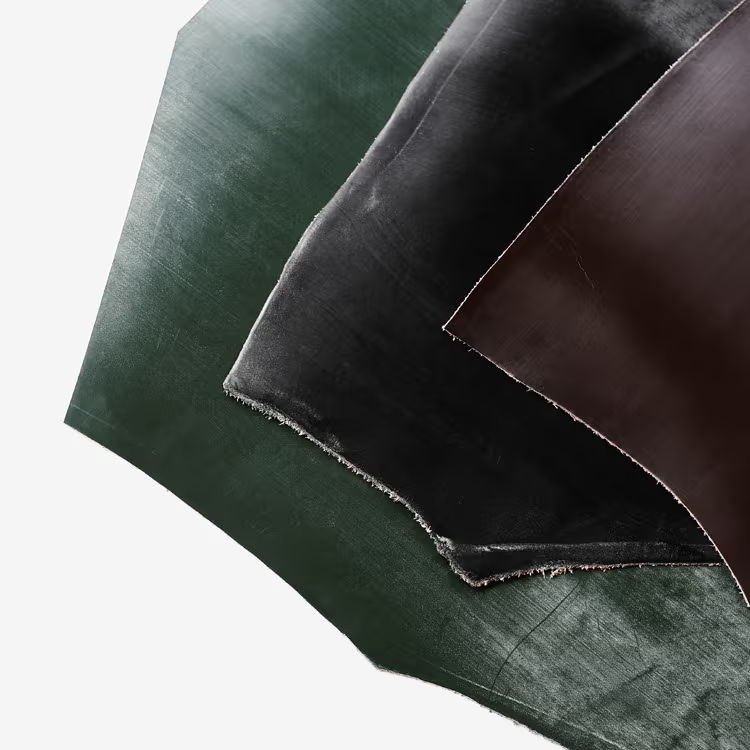 Various pieces of leather in green, black, and brown colors.