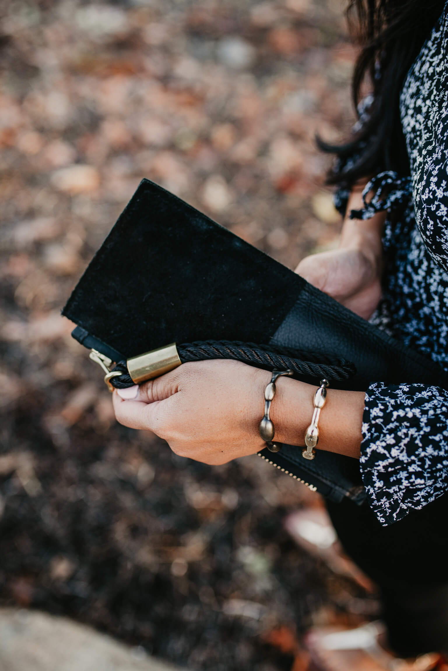 closeup on black leather clutch with black rope wristlet